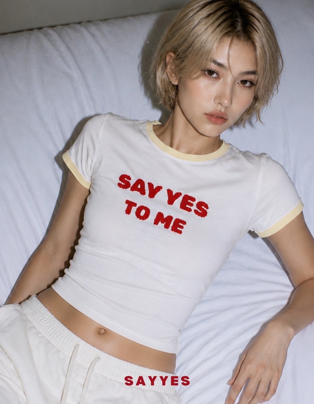 Model reclining in a Say Yes ringer tee, new collection drop campaign
